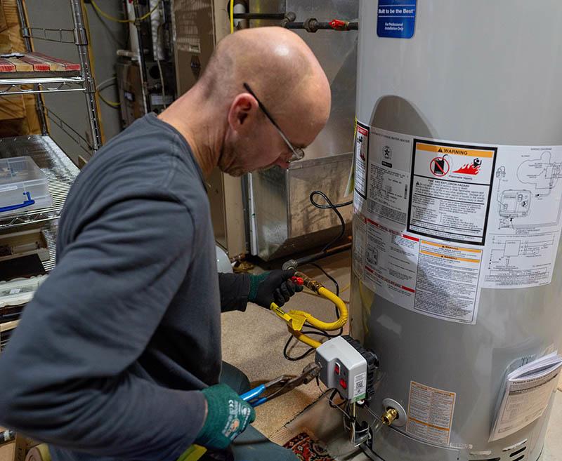 McElroy's plumbing technician works on a gas water heater.