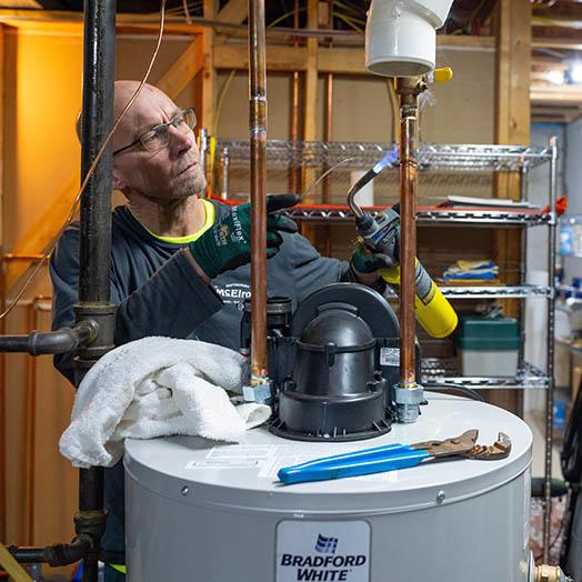 McElroy's plumbing technician hooks up a new water heater.