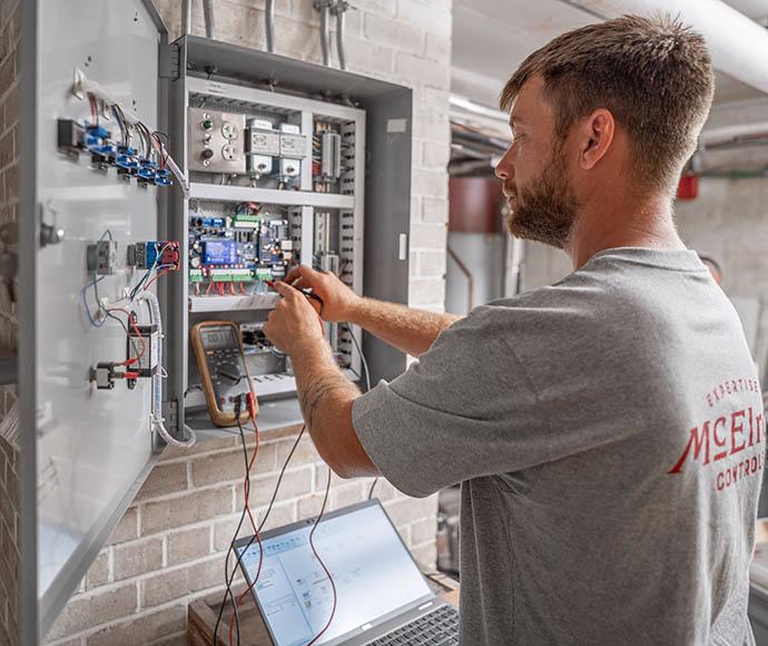 Dylan Hunninghake works on building controls installation.