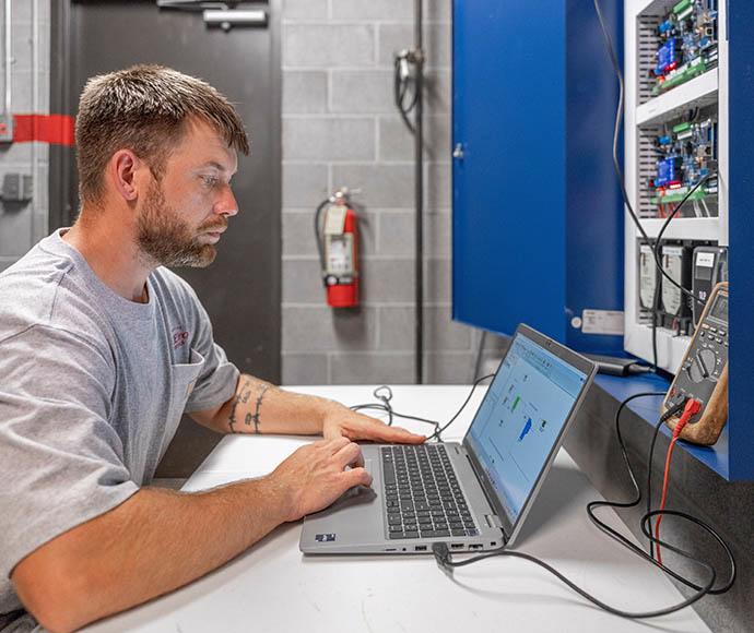 Dylan Hunninghake runs diagnostics on a building controls system.