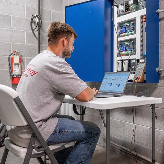 Dylan Hunninghake adjusts programming of a building controls system.