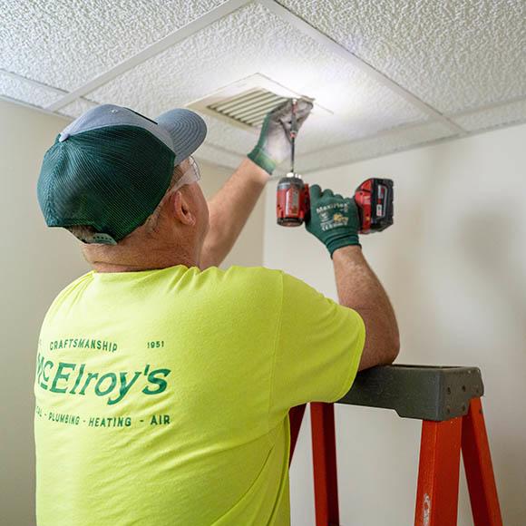 Tech removing screw to inspect smoke damper