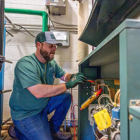 McElroy's HVAC technician servicing boiler.
