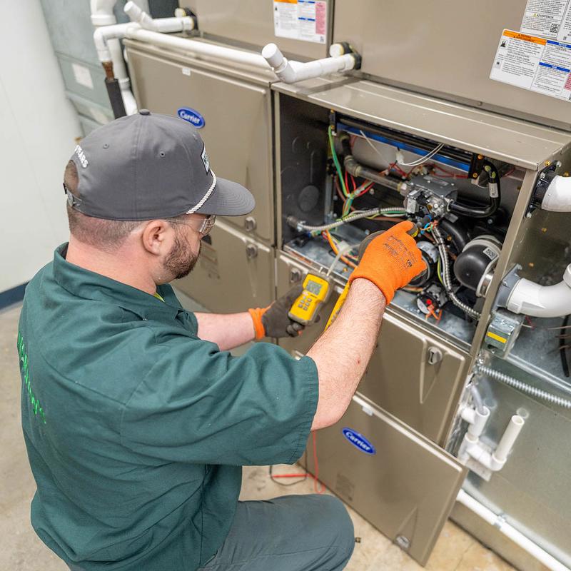 McElroy's HVAC technician servicing equipment.