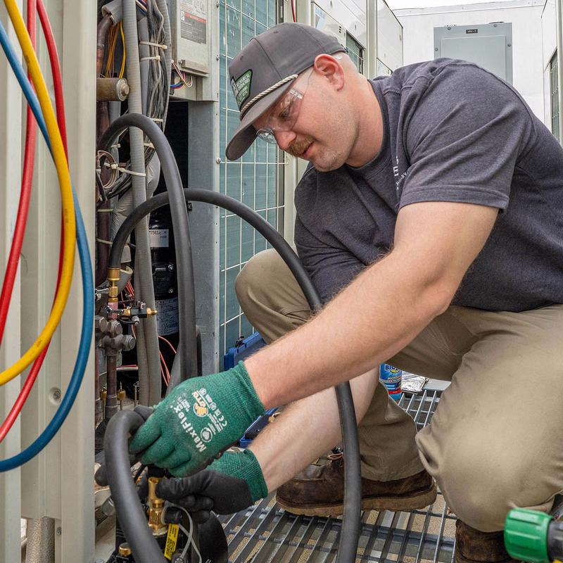 McElroy's HVAC technician servicing equipment.