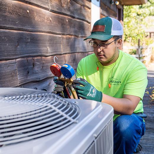 Zach Brinker of McElroy’s checks the pressure in the lines of the new outdoor condensing unit that will help cool this renovated outbuilding for comfortable summer use.