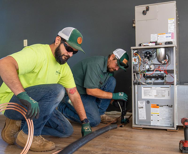 PJ Rocha and Ben Walker of McElroy’s roll out copper pipe for a new heating and air system they’re installing to make an outbuilding comfortable for year-round use.