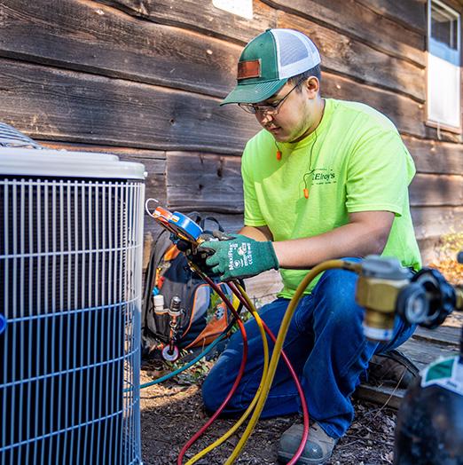 McElroy's residential HVAC technician checks the pressure in the lines of a new outdoor condensing unit .