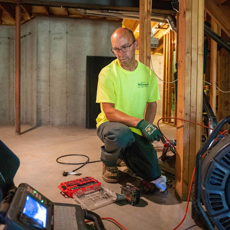 McElroy's plumber watches live video screen while conducting digital video sewer inspection.