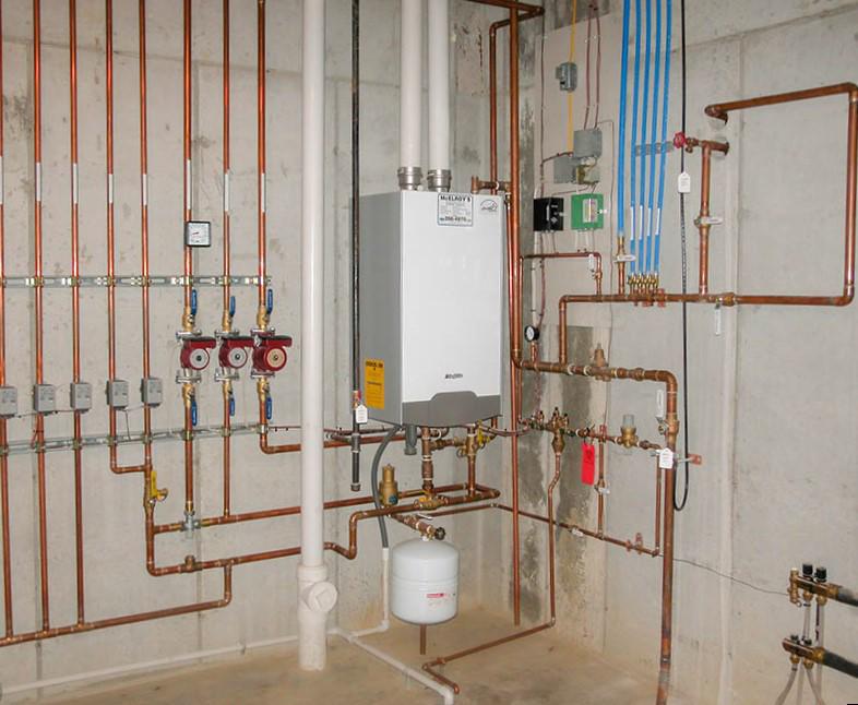 Navien high-efficiency, tankless boiler system with complete array of hot water and return pipes, installed by McElroy's.