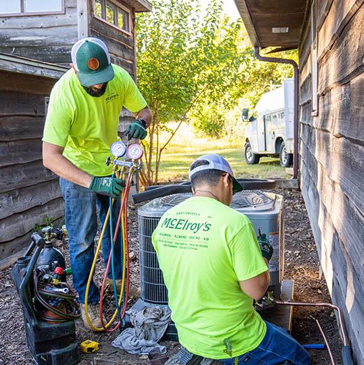 The McElroy's residential HVAC installation team sets up a new air conditioning outdoor unit.