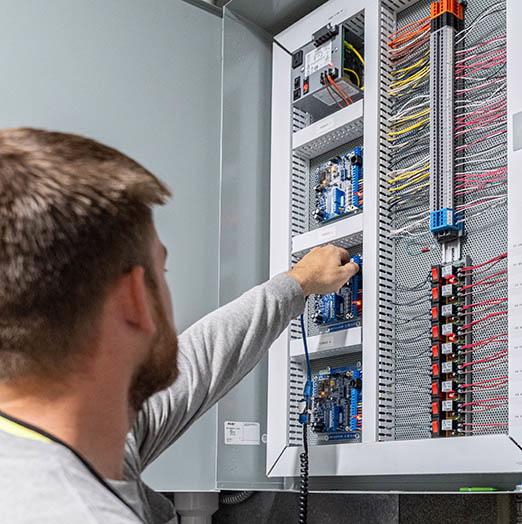 A building-automation technician from McElroy’s performs onsite diagnostic and maintenance service on a building automation system.