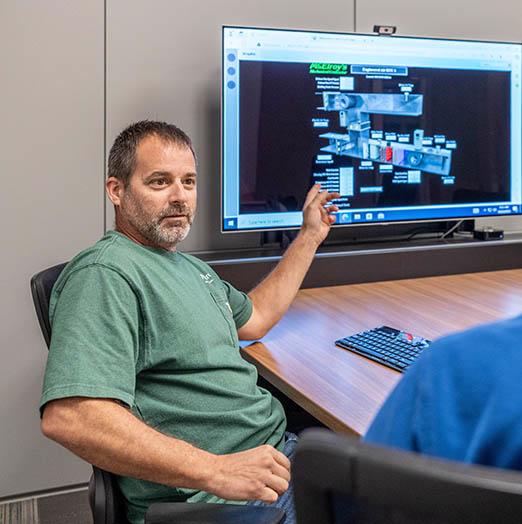 Keith Watkins, McElroy's commercial HVAC service manager, reviews online building-automation data and diagrams with a customer.