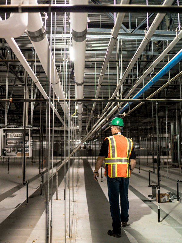 Wade Jueneman inspects pipe array design-built by McElroy's