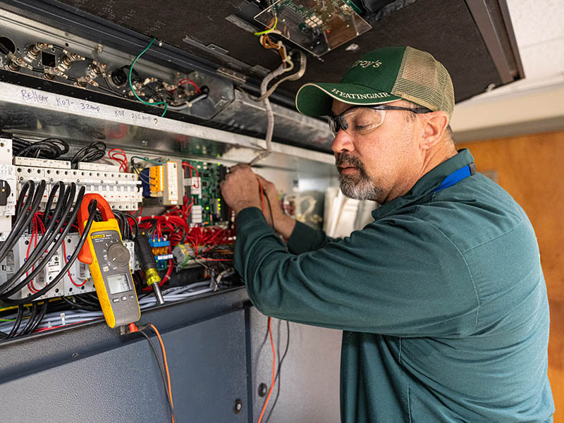 Doug Stuewe checks voltage on a computer-room air conditioning unit.