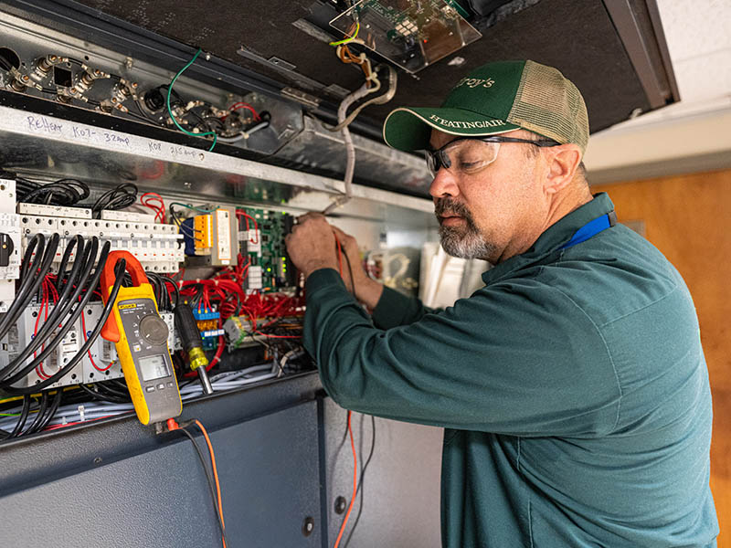 Doug Stuewe checks voltage on a computer-room air conditioning unit.