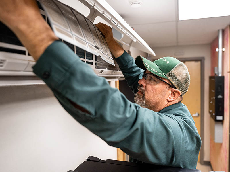 Doug Stuewe puts a clean air filter into a mini-split heating and cooling unit.