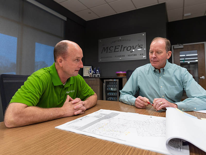 Wade Jueneman, McElroy's vice president, and Dan Beal, McElroy's president, discuss plans for a construction project.