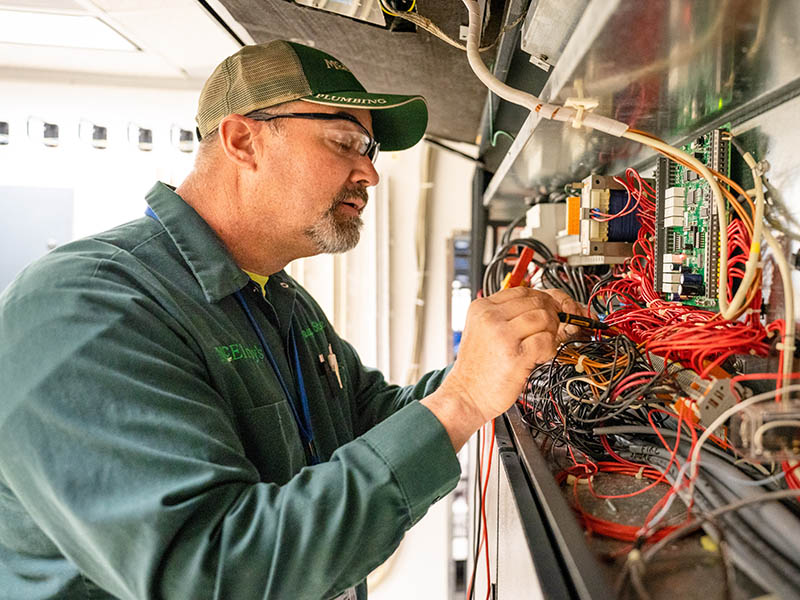 Doug Stuewe performs maintenance on a computer-room air conditioning unit.