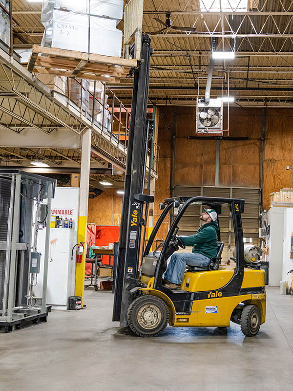 Rhett Reynolds operates a forklift in the McElroy’s construction plumbing warehouse and prefabrication facility.