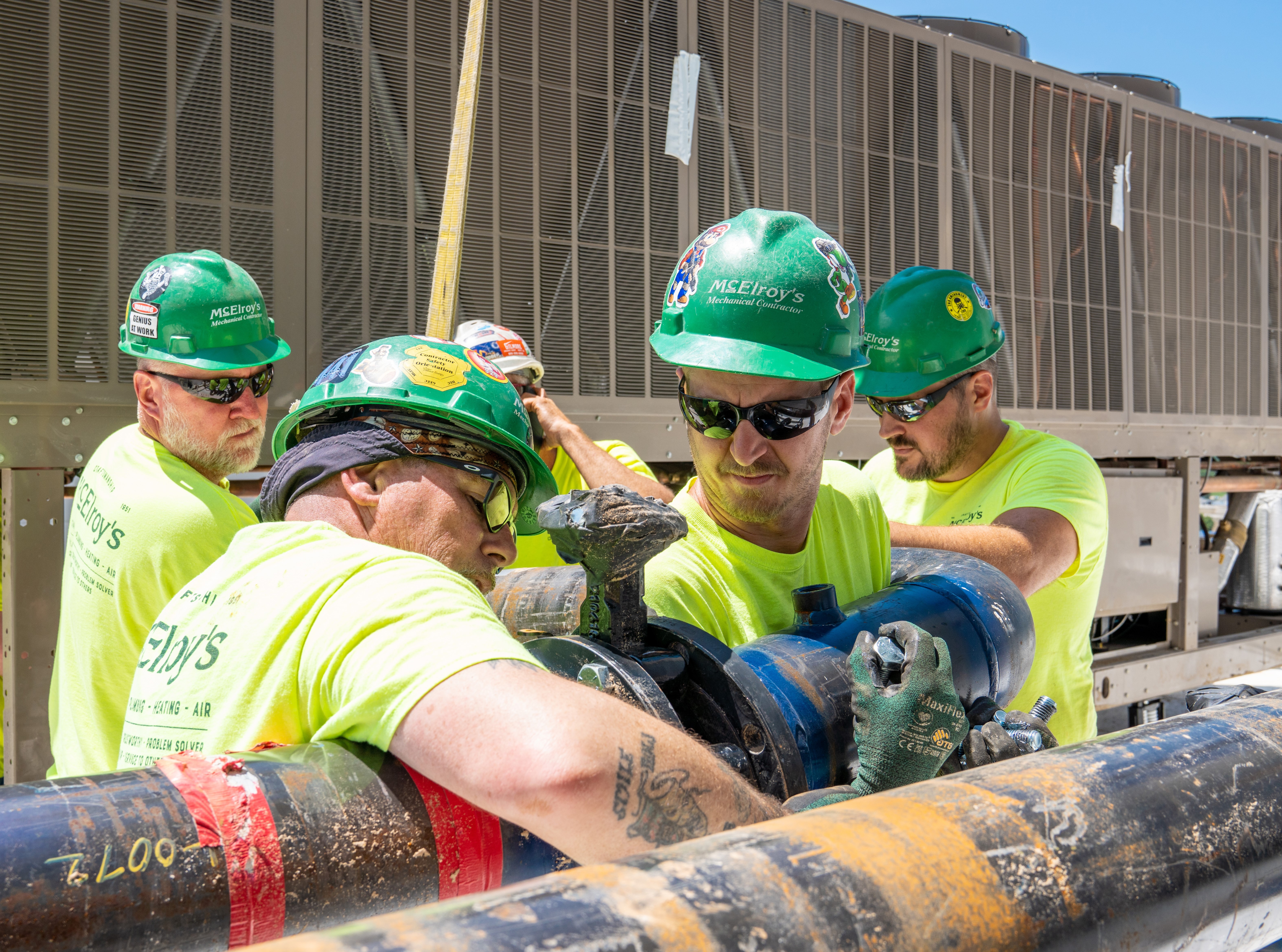 Brian Bergquist, McElroy’s commercial construction foreman, works side-by-side with his team connecting rooftop chiller pipes.