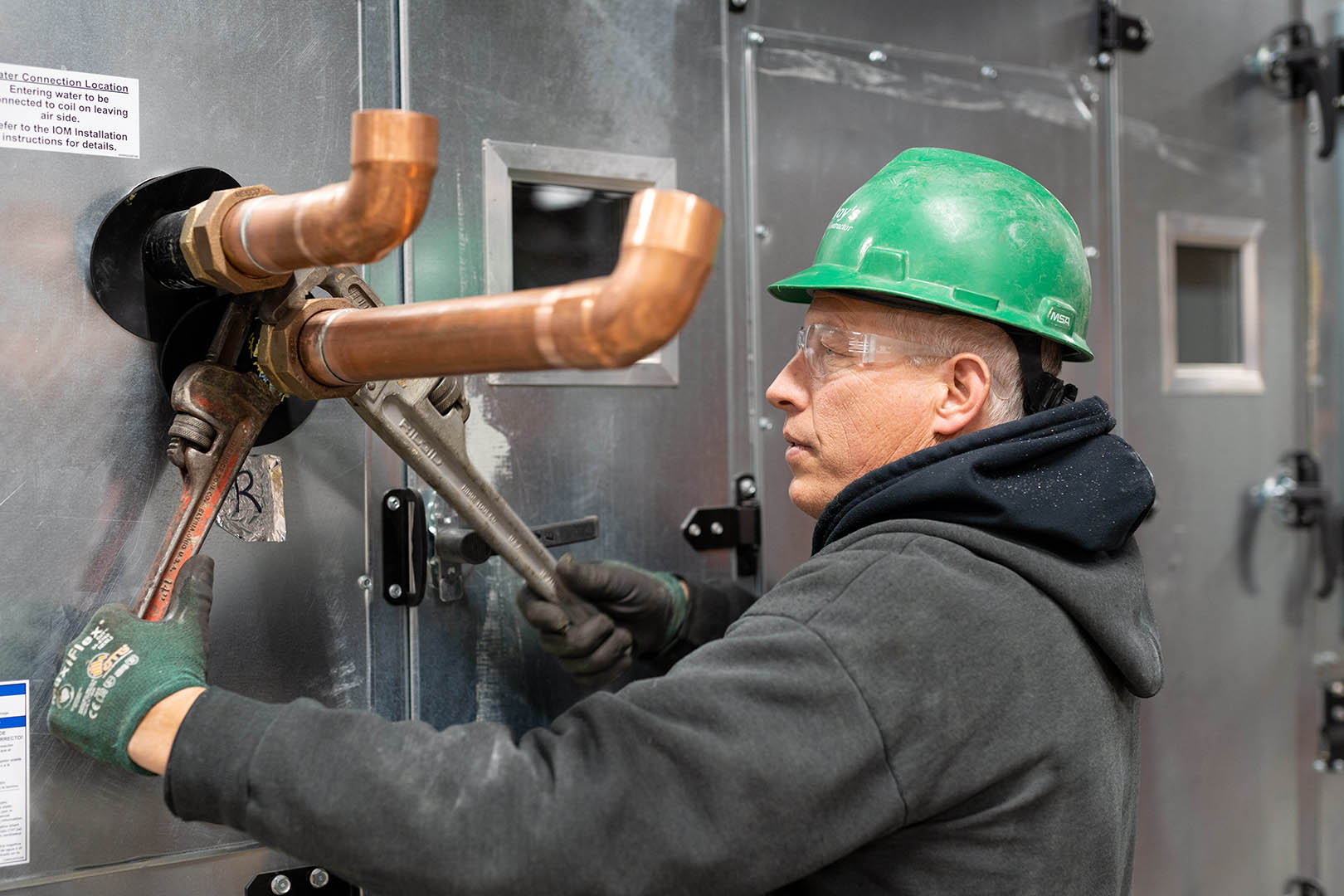 McElroy’s commercial construction plumbing technician, Jim Konrade, tightens piping connected to a medical facility air-handling unit.