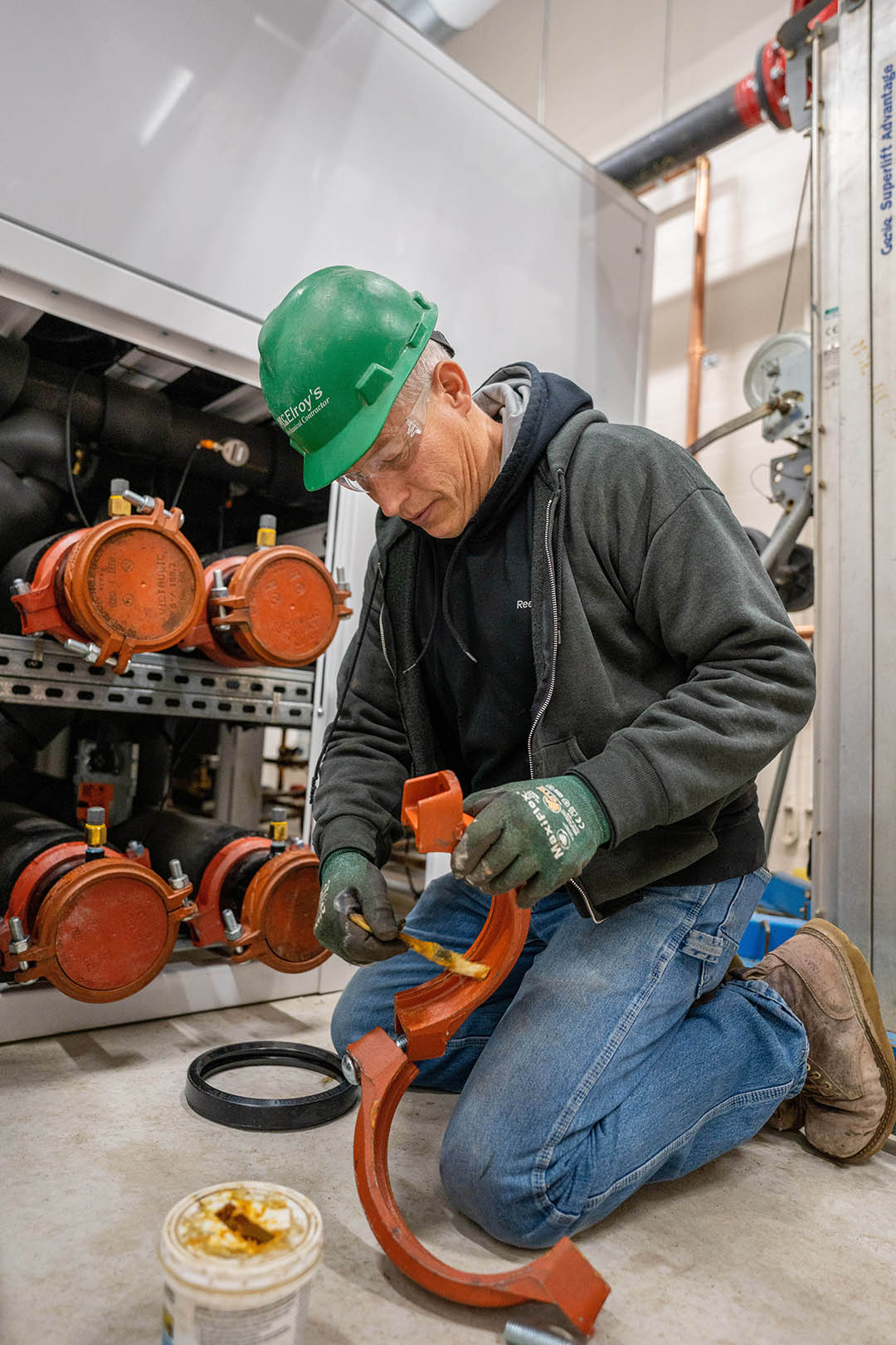Jim Konrade of McElroy’s applies lubricant to help seat a gasket in a Victaulic pipe fitting at a medical facility expansion.