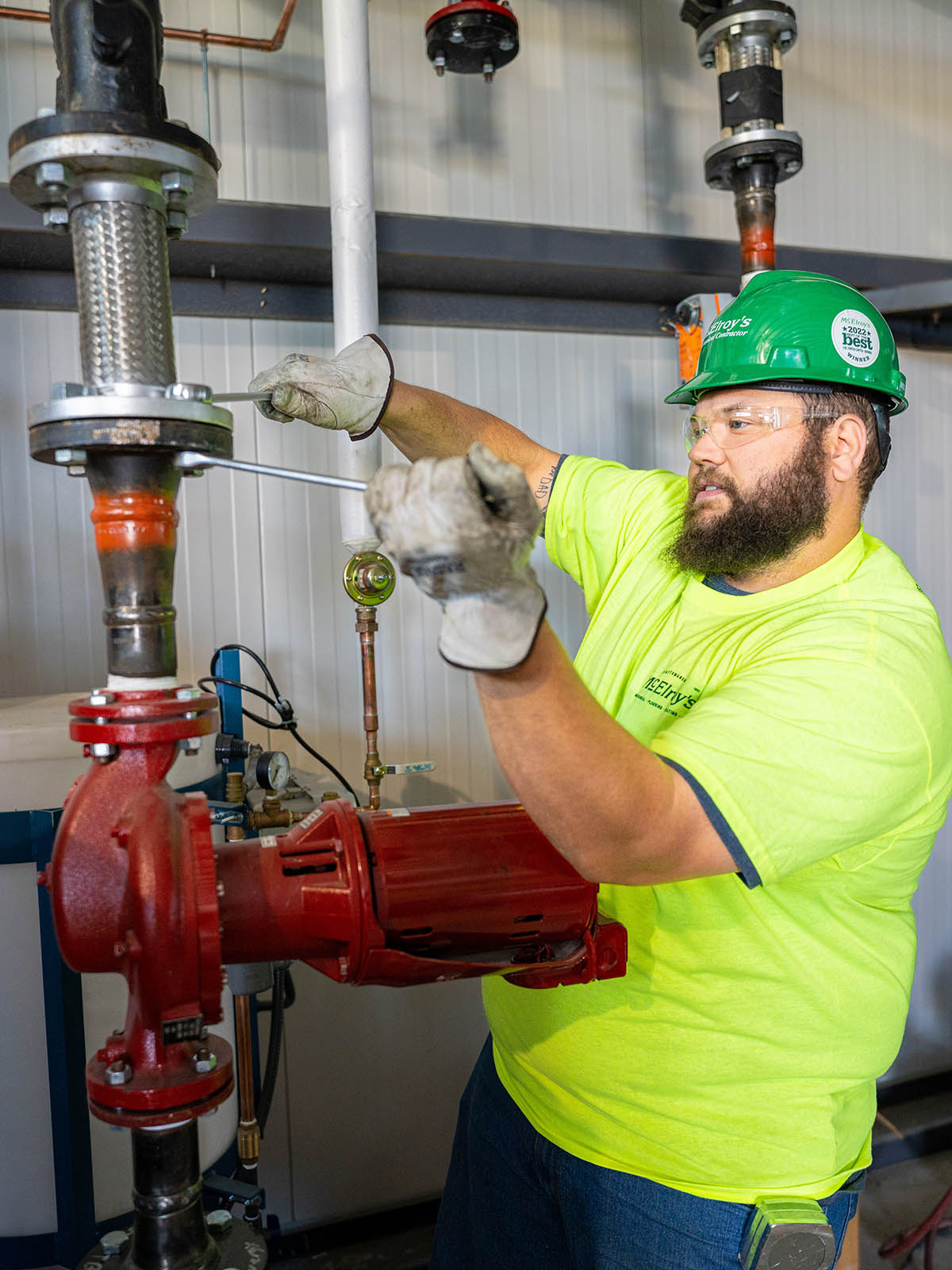 Chris Perkins of McElroy’s tightens bolts securing a flexible metal pipe at the new Evergy Emporia Service Center.