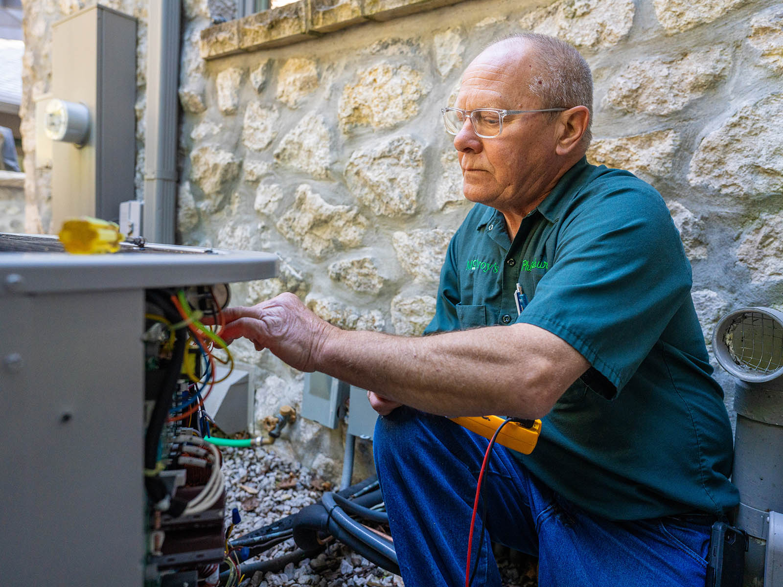 Phil Salsbury, McElroy’s HVAC service technician, fine tunes a residential customer’s air-conditioning condenser unit.