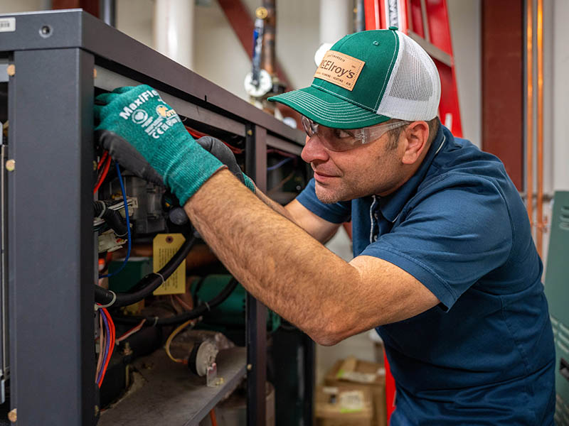 At a north Topeka health clinic, Phil Harper, McElroy’s commercial project supervisor, works on the electronics of a boiler.