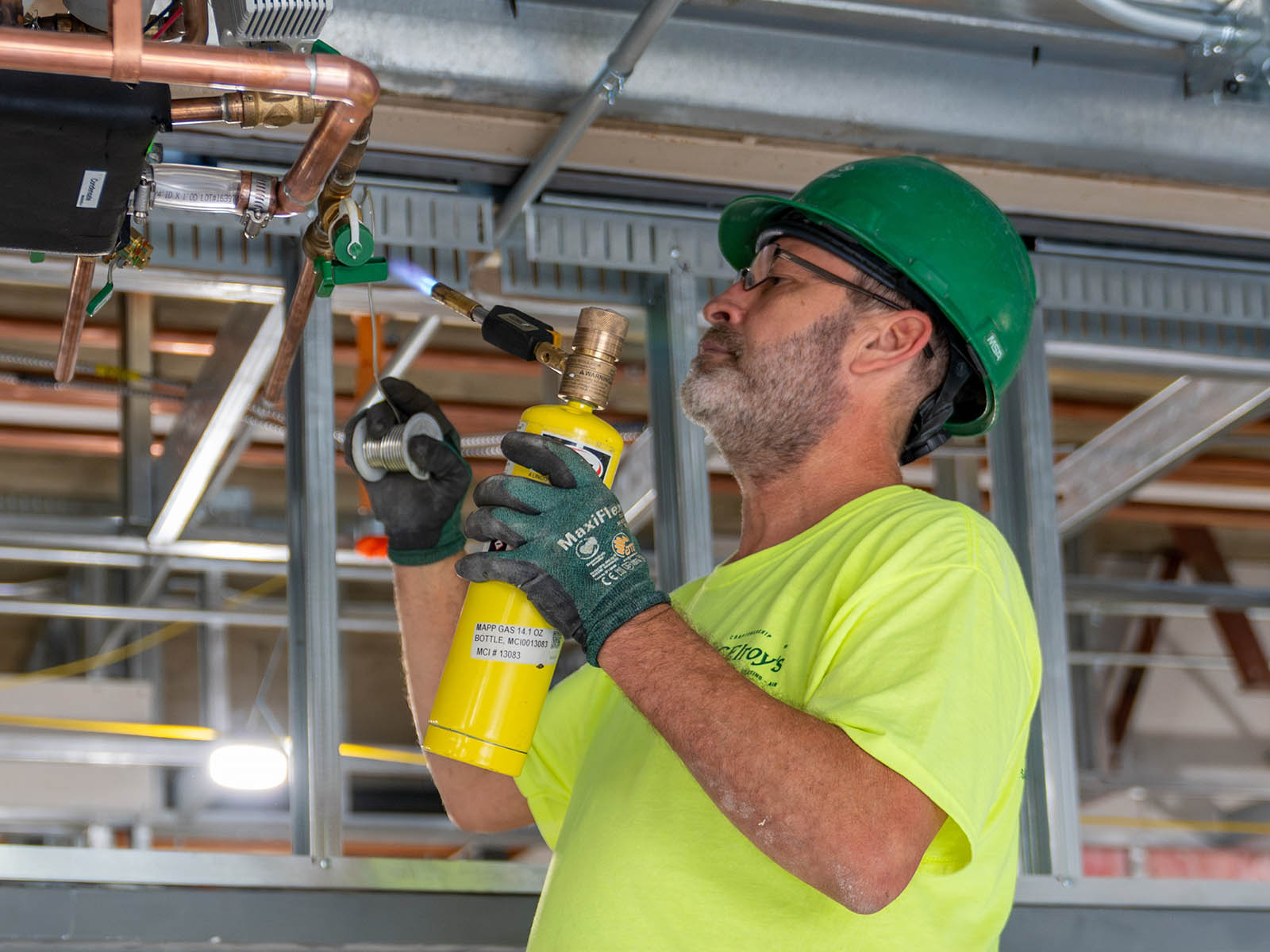 Shane Hillebert, McElroy’s commercial construction pipefitter, applies solder to a copper pipe at Brewster Place, in Topeka.