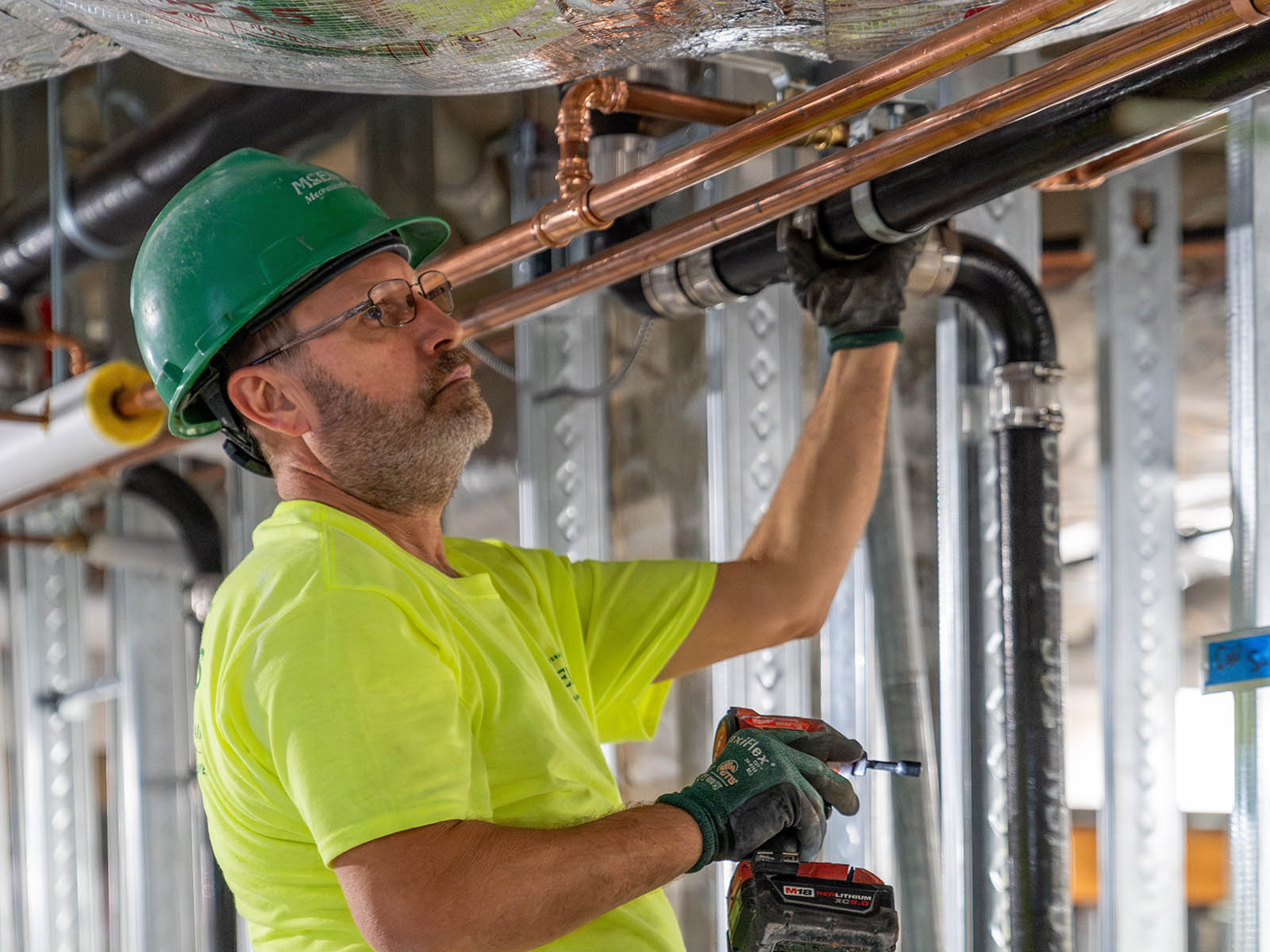 Shane Hillebert, McElroy’s commercial construction pipefitter, carefully checks the alignment of the piping system he is building.