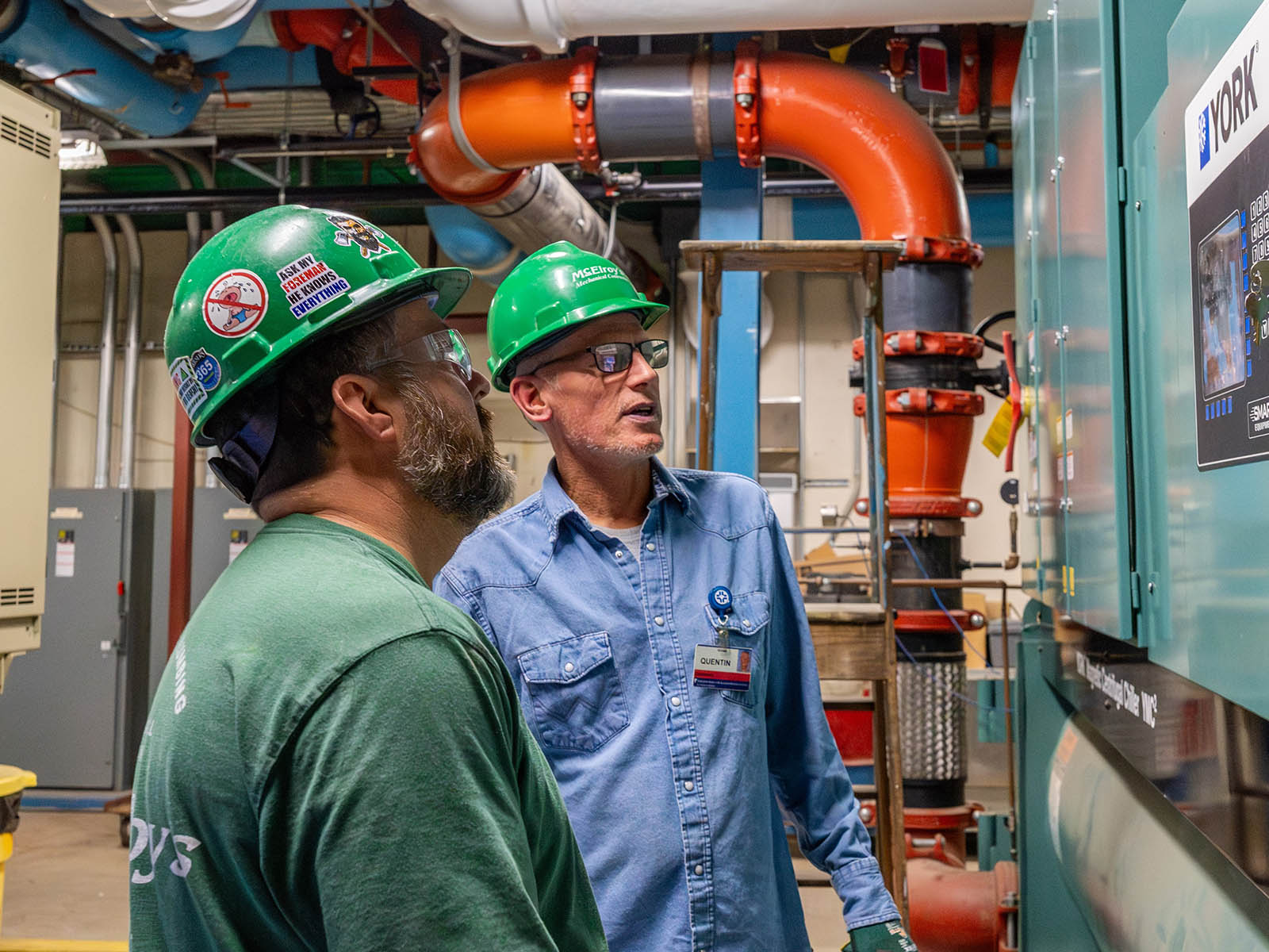 McElroy’s commercial construction pipefitters, Mat Herl and Quentin Latta, discuss a project.