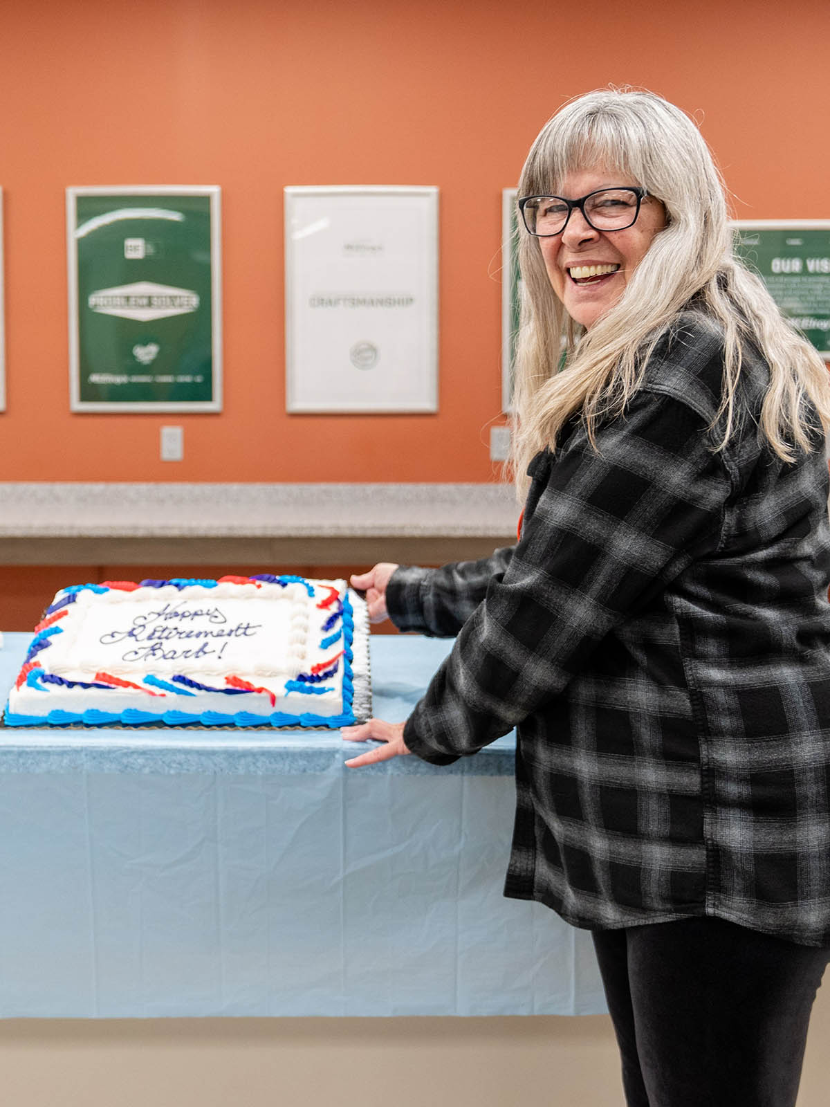 Barb Rittenhouse shows off her retirement cake at her retirement party, December 14, 2023.