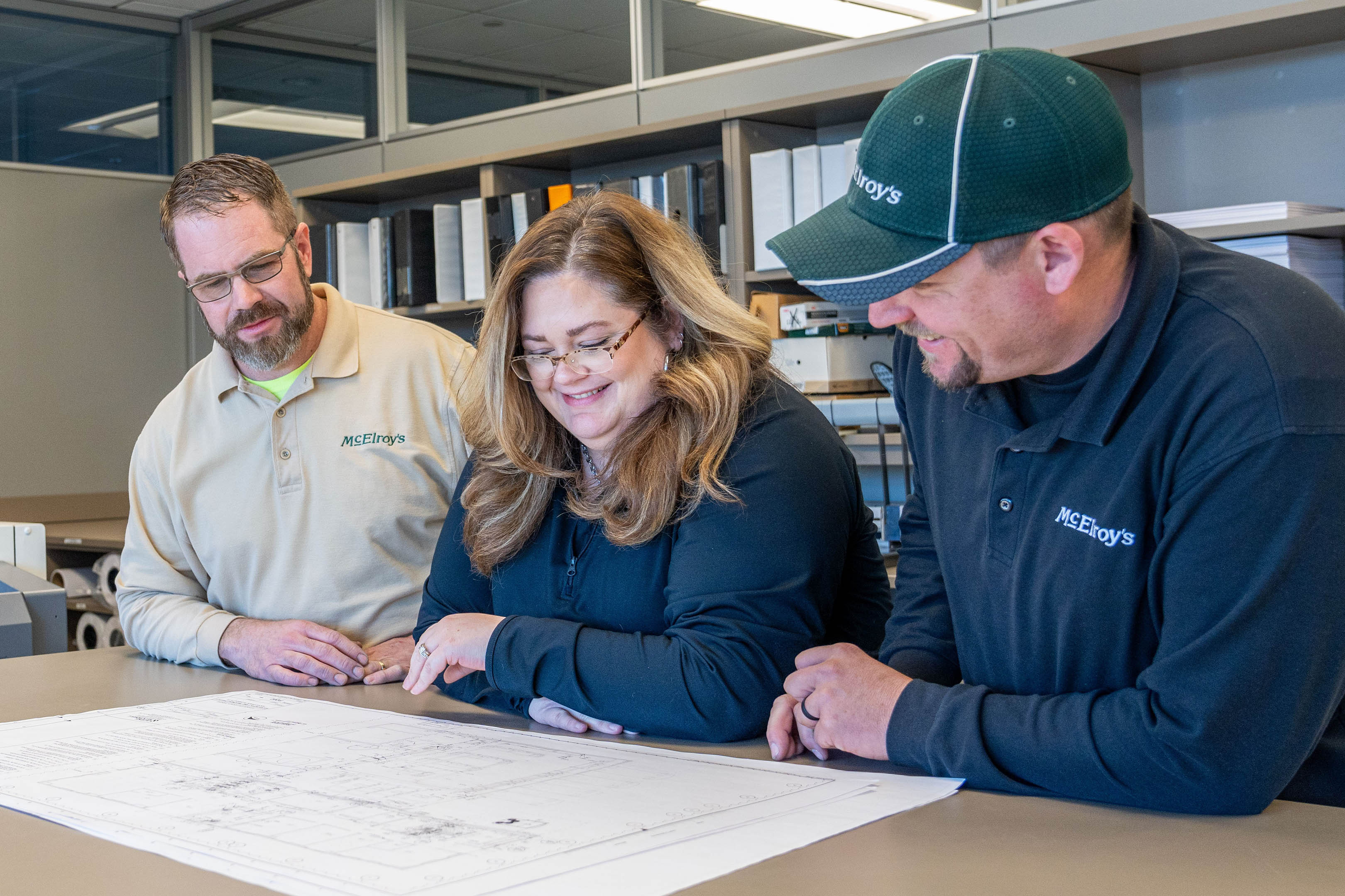 Kristen Colvin discusses building construction plans with McElroy’s project supervisors Scott Schneider and Preston Bond.