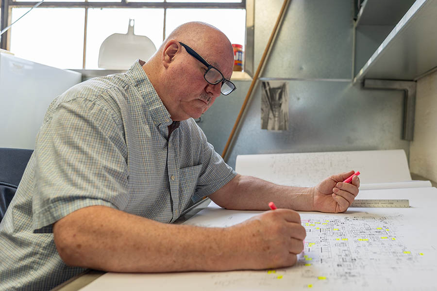Martin Decker, Jr., McElroy’s sheet metal manager, makes notes on the plans for a commercial construction project.