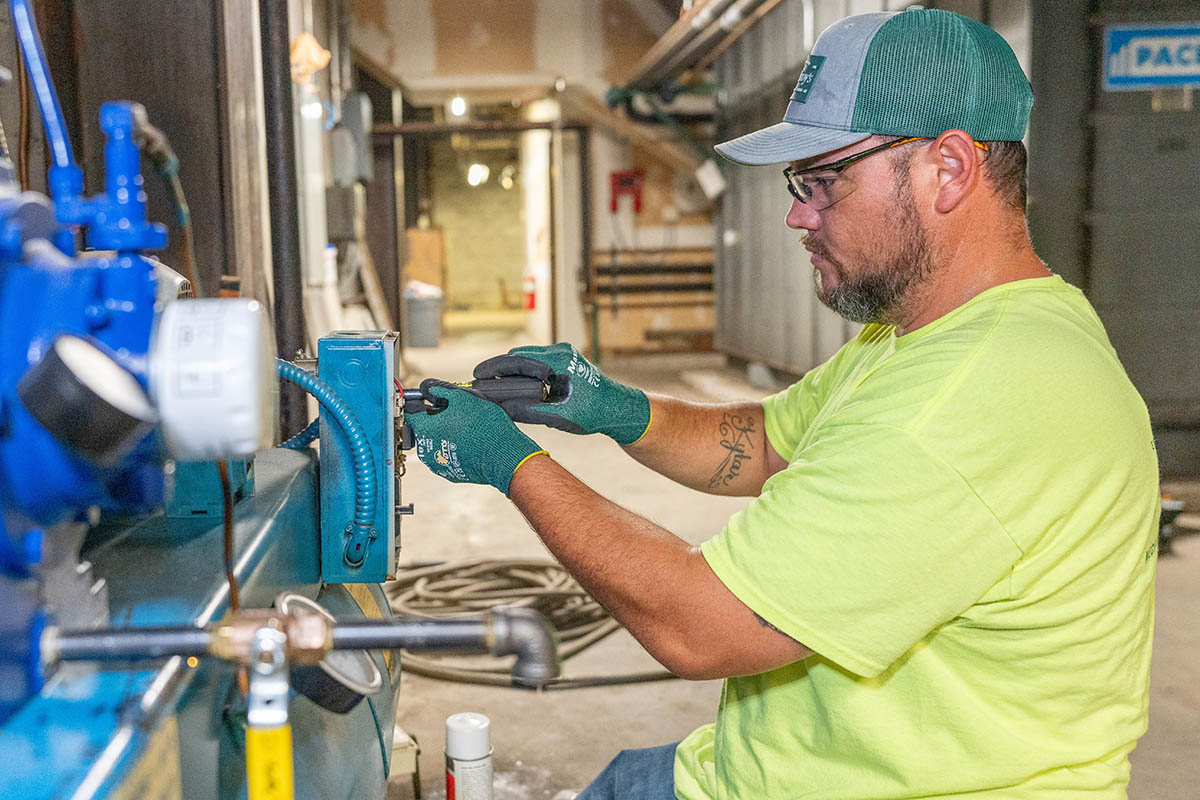 Shawn Brown, McElroy’s commercial HVAC service technician,  makes adjustments on a commercial HVAC system.