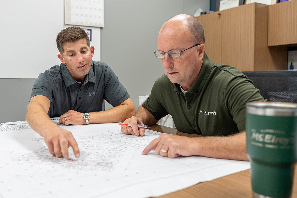 Jimmy Thomas, McElroy’s commercial project manager, reviews commercial construction plans with Wade Jueneman, McElroy’s president.
