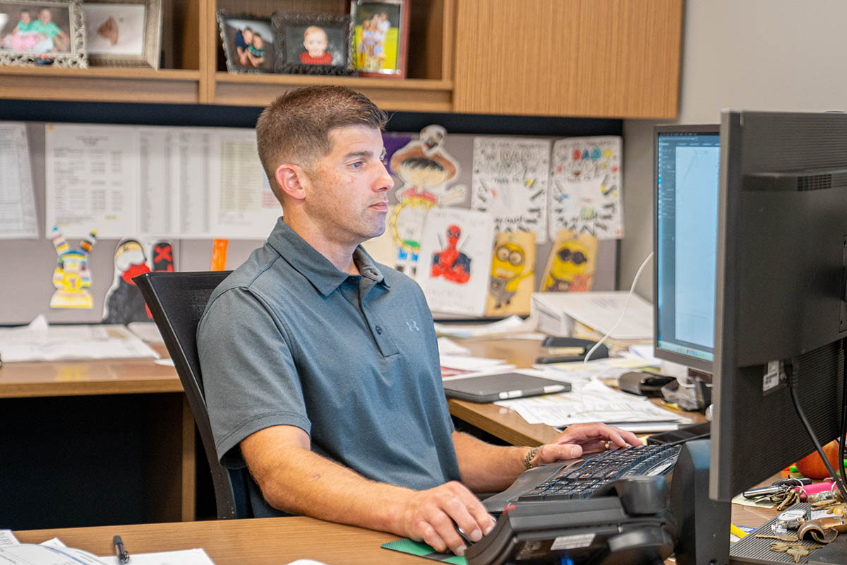 Jimmy Thomas, commercial project manager and estimation team leader, works surrounded by photos of, and artwork by, his kids.