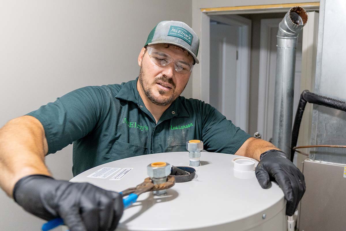 Lee Larson, McElroy’s plumber, begins installation of a new residential water heater.
