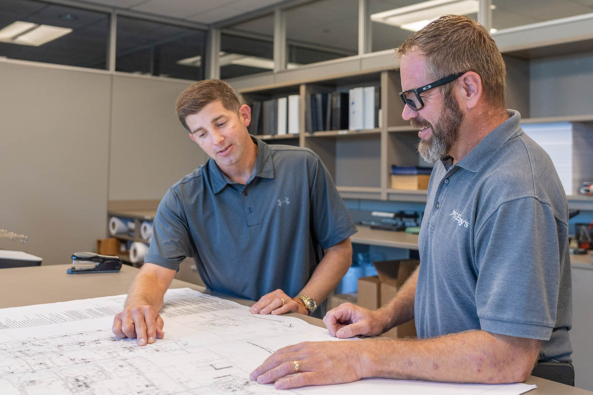 Scott Schneider, McElroy’s commercial project supervisor, discusses a job with Jimmy Thomas, McElroy’s commercial project manager.