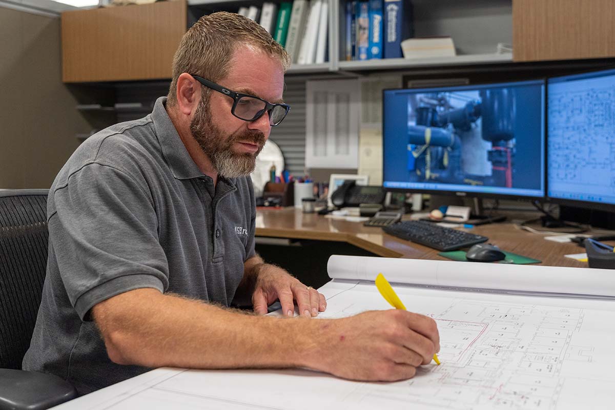 Scott Schneider, McElroy’s commercial project supervisor, makes notes on the plans of a large-scale construction project.