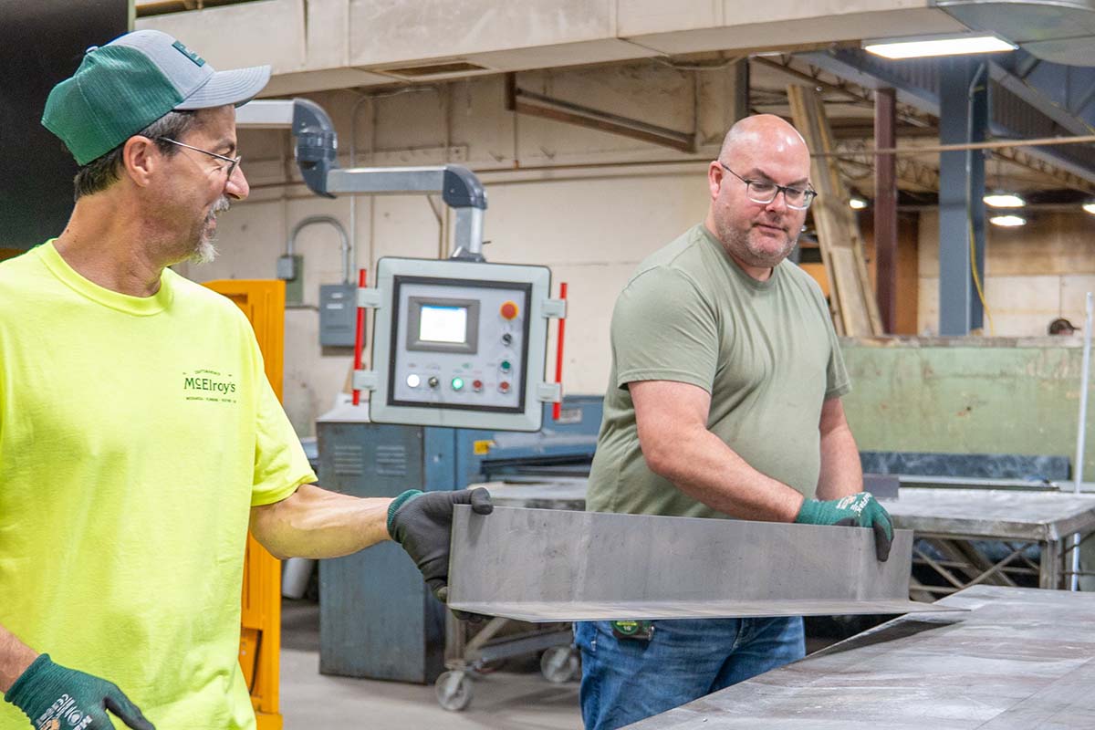 David Dechand, McElroy’s sheet-metal shop steward and Anthony Decker, shop foreman, work together to bend a metal plate.