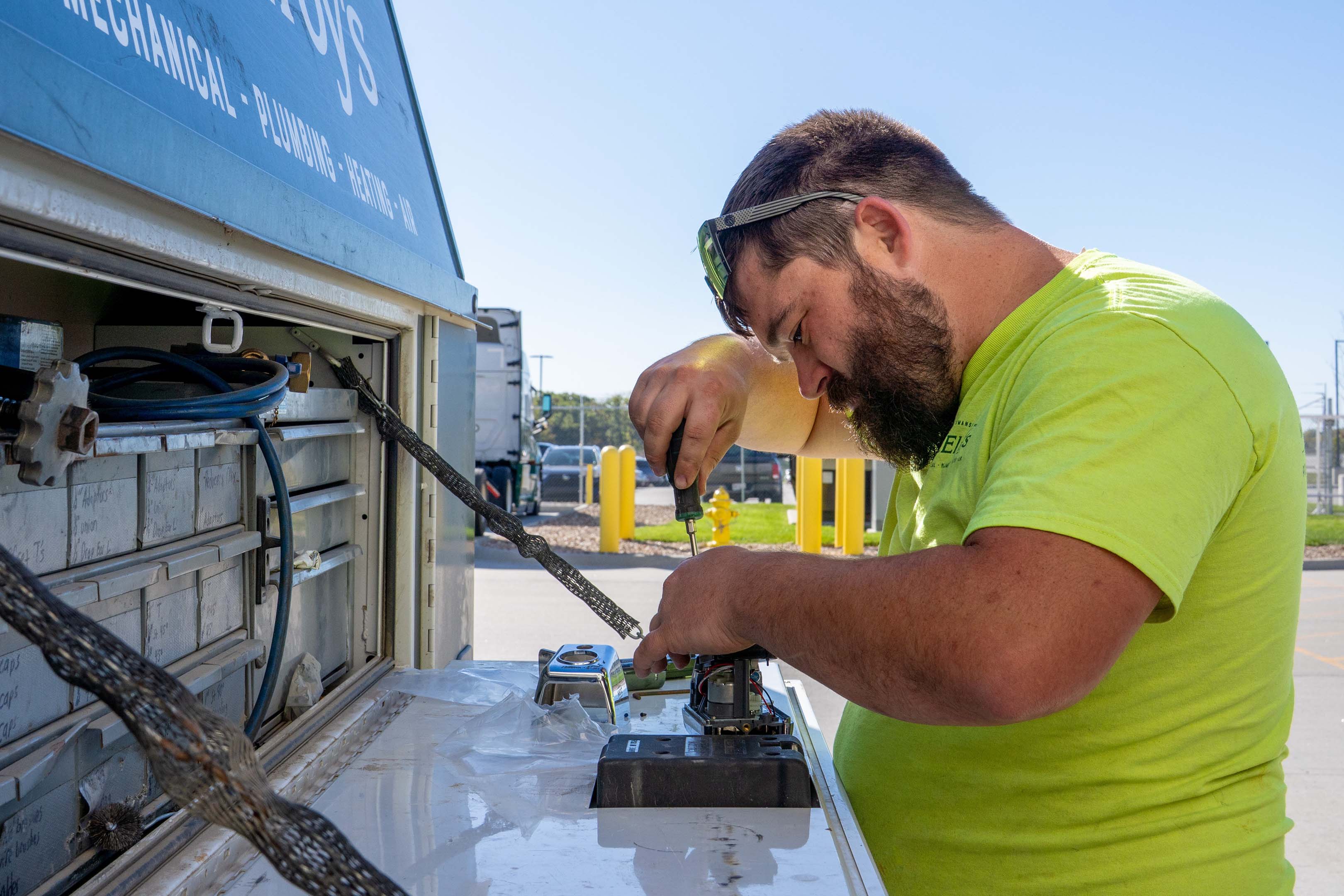 McElroy’s plumber Keith Gerisch makes fine-tuned adjustments on an automatic flushing unit.