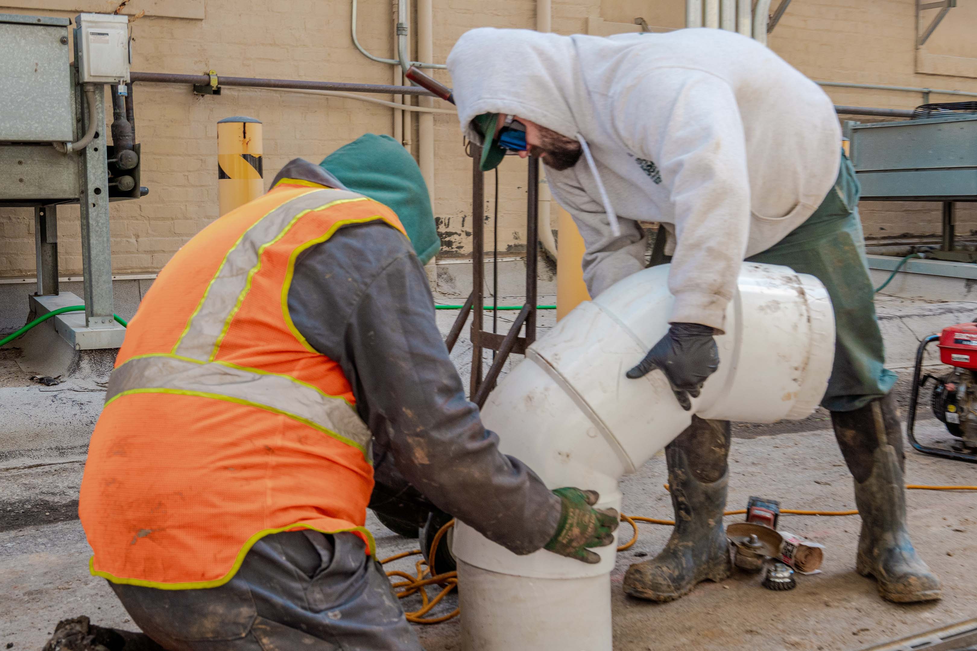 Keith Gerisch and Shawn O’Malley, both of McElroy’s, work together on a major pipe repair in downtown Topeka.