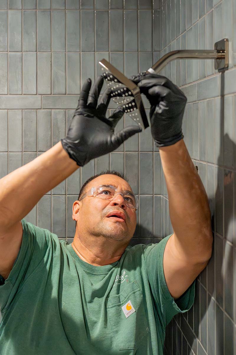 Junior Barajas, McElroy’s plumber, installs a new residential shower head.