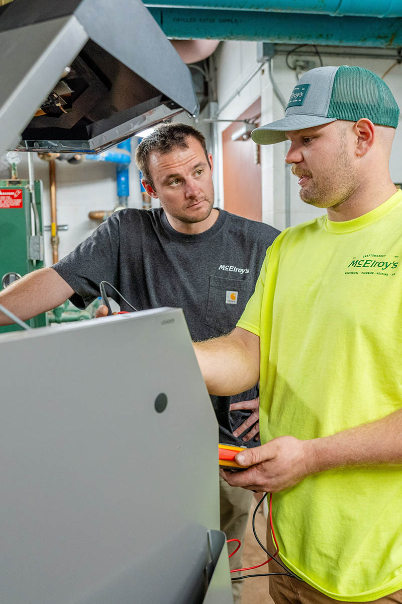 Brit Hunsicker and Trevor Boudeman, McElroy’s commercial HVAC service tech, discuss a maintenance project onsite.