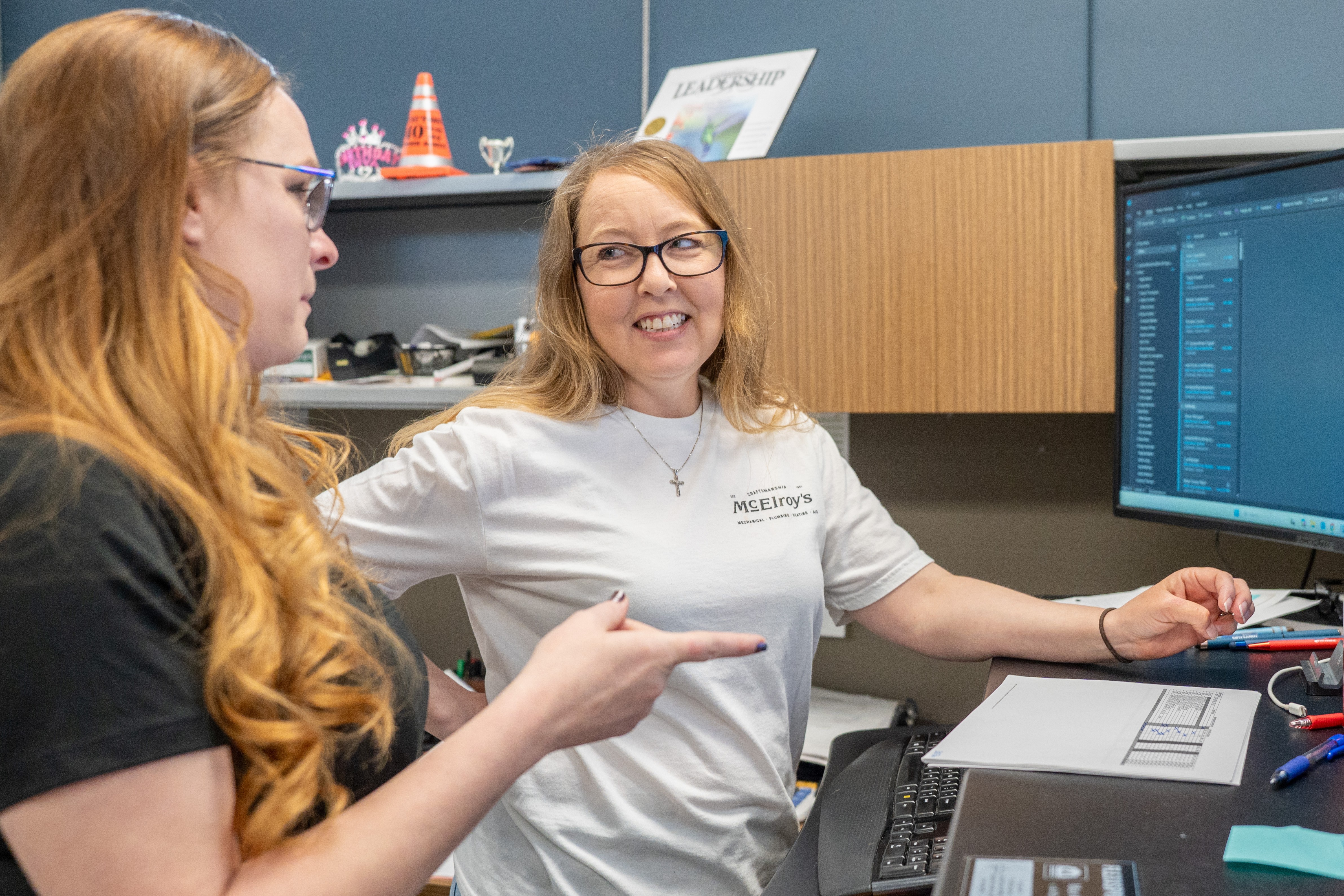 Cassie Benton, McElroy’s customer service manager, discusses a project with Kim Davidson, commercial HVAC service rep.