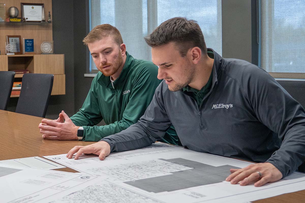 Ben Post, McElroy’s project manager and licensed professional engineer, reviews printed project drawings with Dillon Byrne.